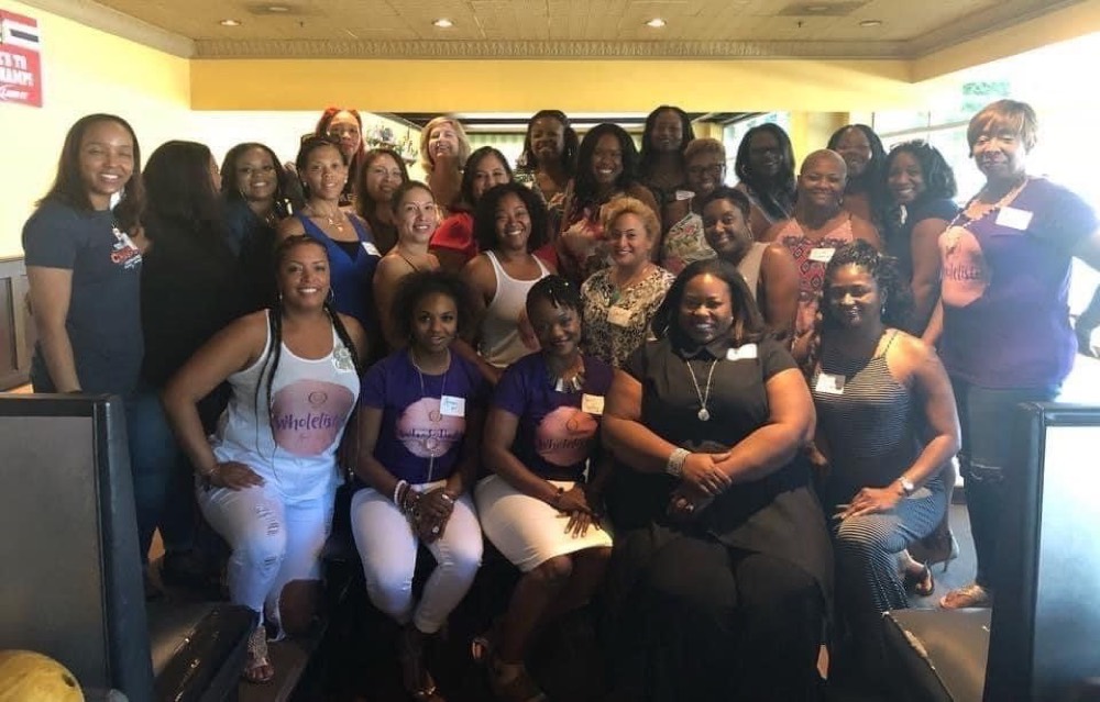 Qiana with a large group of women at a Wholelistic event