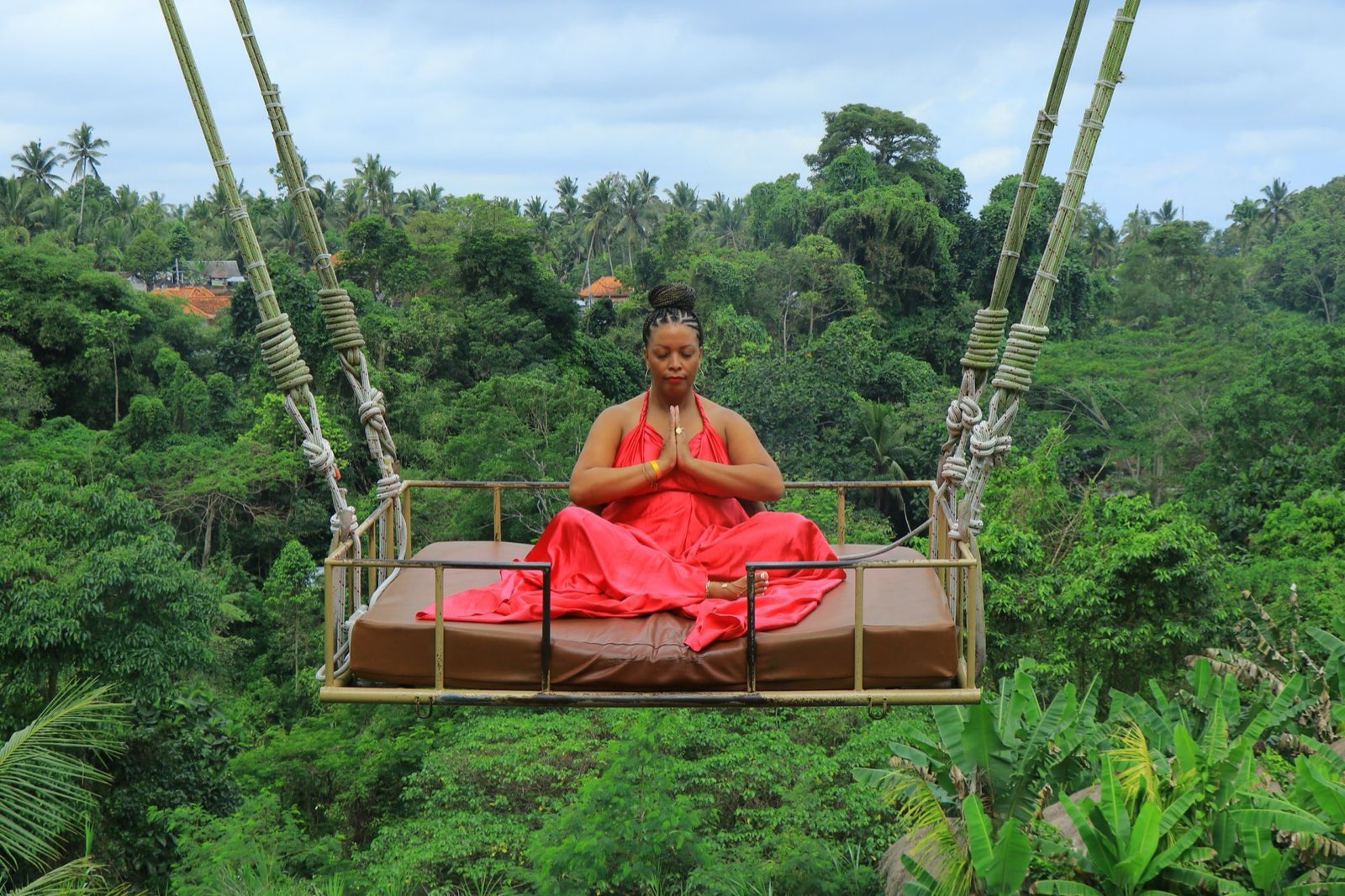 Qiana meditating on a jungle swing bed